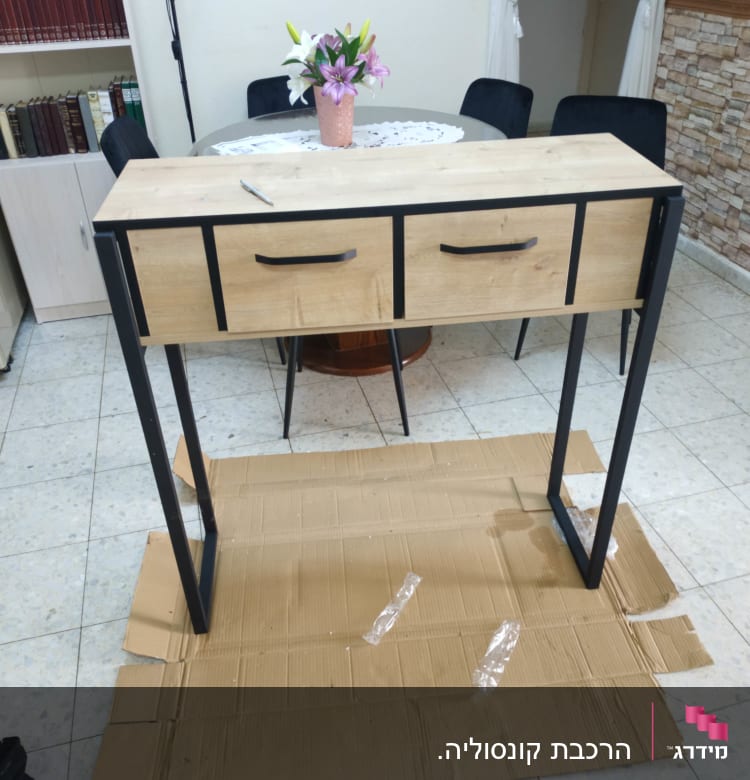 שולחן עץ עם מגירות על קרטון ברצפה